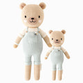 Charlie the honey bear in the regular and little sizes, shown from the front. Charlie is wearing blue, corduroy-textured overalls with a little bee stitched above his chest pocket.