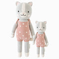 Daisy the kitten in the regular and little sizes, shown from the front. Daisy is wearing a pink romper with daisies embroidered onto it and bows on the shoulders.