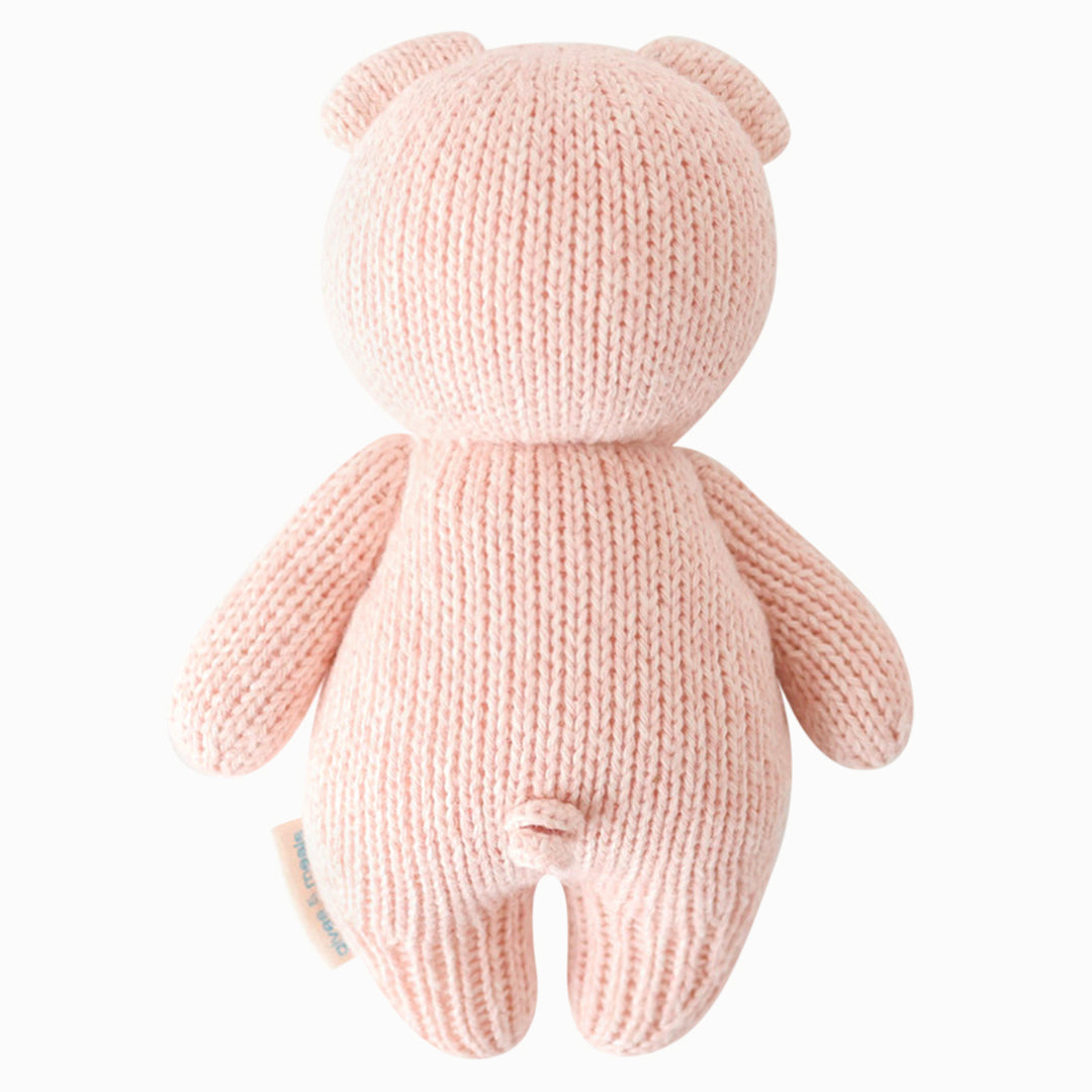 The baby piglet stuffed animal shown from the back. Baby piglet has a teeny spiraled tail.