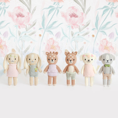 The entire Tiny Collection, shown standing in front of a soft floral background.