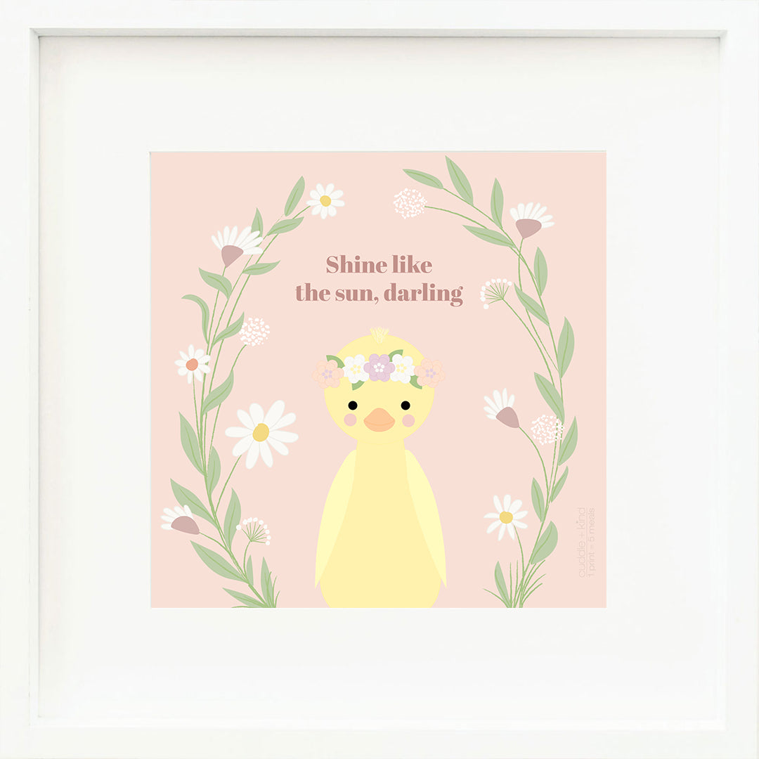 An inspirational print with a graphic of Flora the duckling on a pink background with leafy, floral vines rising from bottom to top and words that say “Shine like the sun, darling” in mauve.