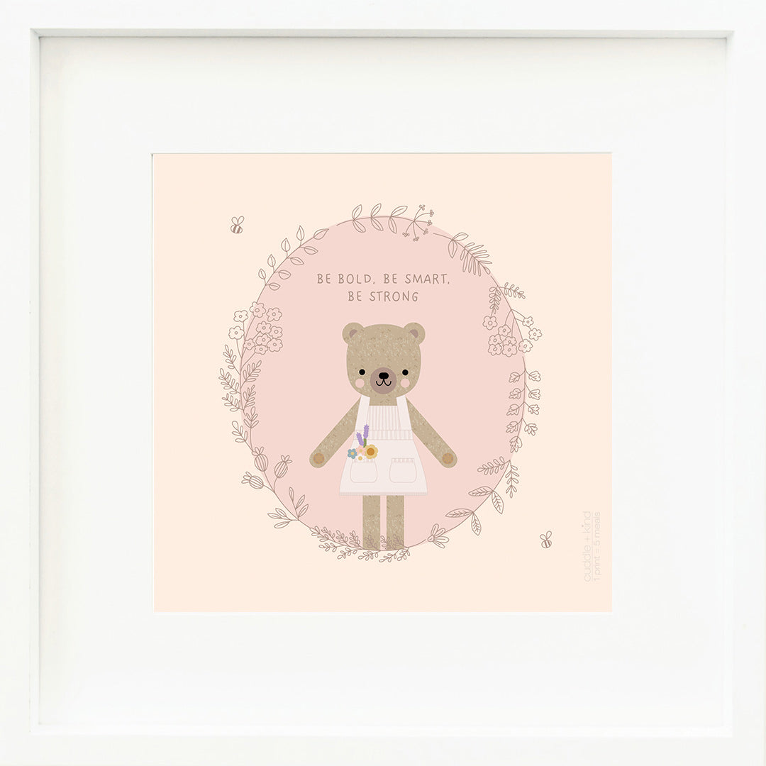 A framed print with a drawing of Goldie the honey bear and text that says “Be bold, be smart, be strong.”