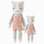Daisy the kitten in the regular and little sizes, shown from the front. Daisy is wearing a pink romper with daisies embroidered onto it and bows on the shoulders.