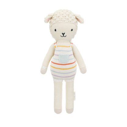 Avery the lamb shown from 360°. Avery is wearing a pair of rainbow striped overalls with a light blue pocket on the front.