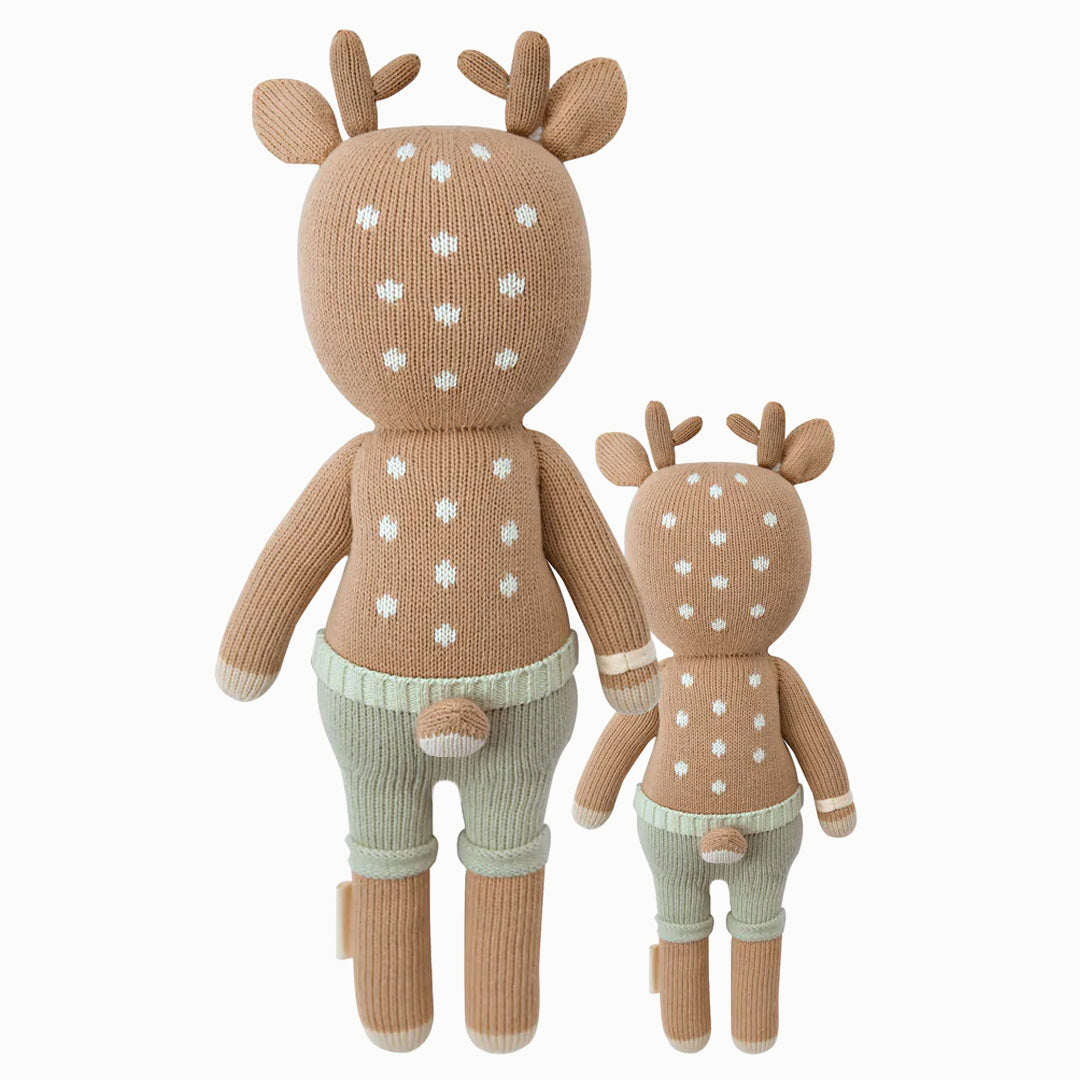 Cuddle and kind doll Elliott the fawn in the regular and little sizes, shown from the back. Elliott’s tail is poking out the back of his shorts.