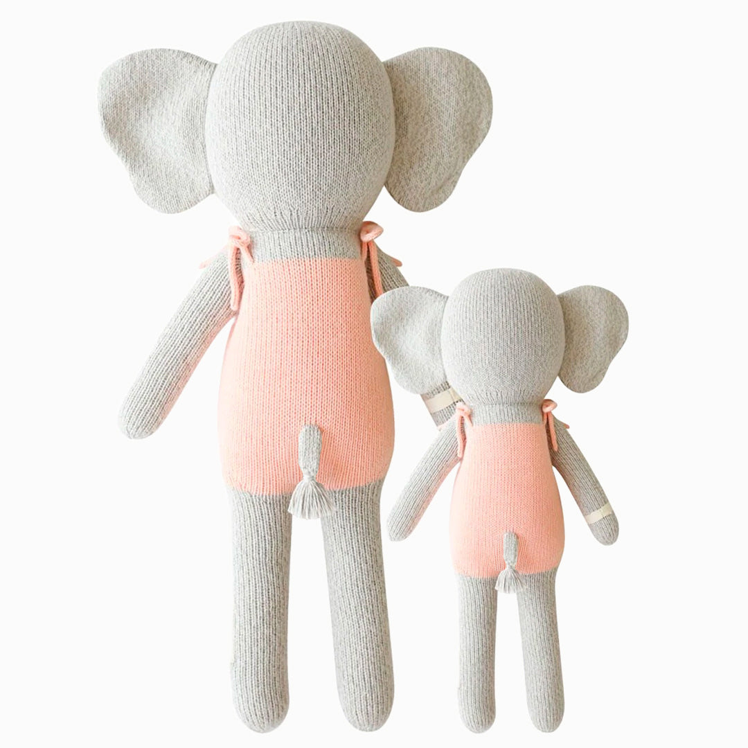Cuddle and kind doll Eloise the elephant in the regular and little sizes, shown from the back. Eloise’s tail is poking out the back of her romper, and has a tassel on the end.