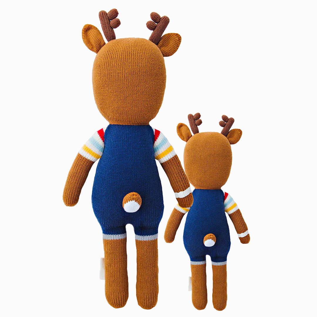 Cuddle and kind doll Scout the deer in the regular and little sizes, shown from the back. Scout’s tail is poking out the back of his overalls.