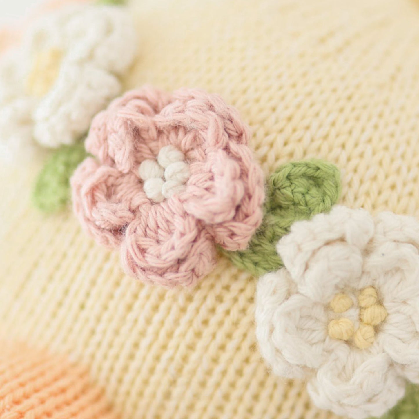 A close-up showing the hand-knit details on Flora’s flower crown.