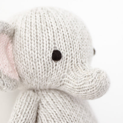 A close up showing the hand-knit details on baby elephant, including its hand-knit ears and trunk.