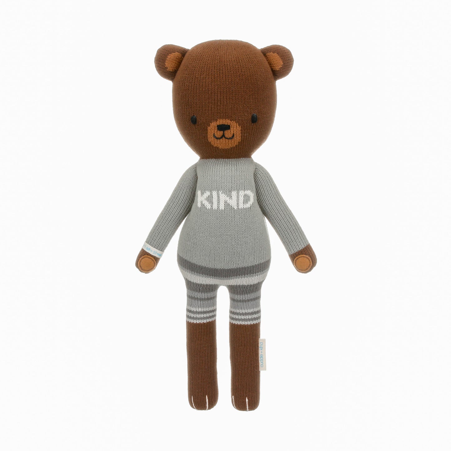 Oliver the bear shown from 360°. Oliver has grey shorts and a sweater that says “Kind.”