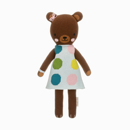 Ivy the bear shown from 360°. Ivy has a blue dress with big green, blue, yellow and pink polka dots, and a pink bow on her head.