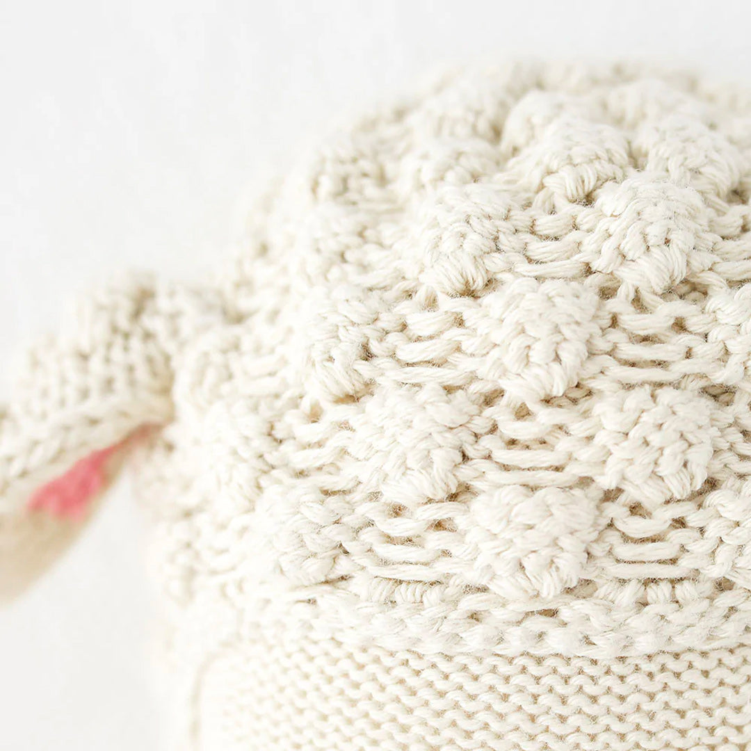 A close-up showing hand-knit details on Lucy the lamb’s head.
