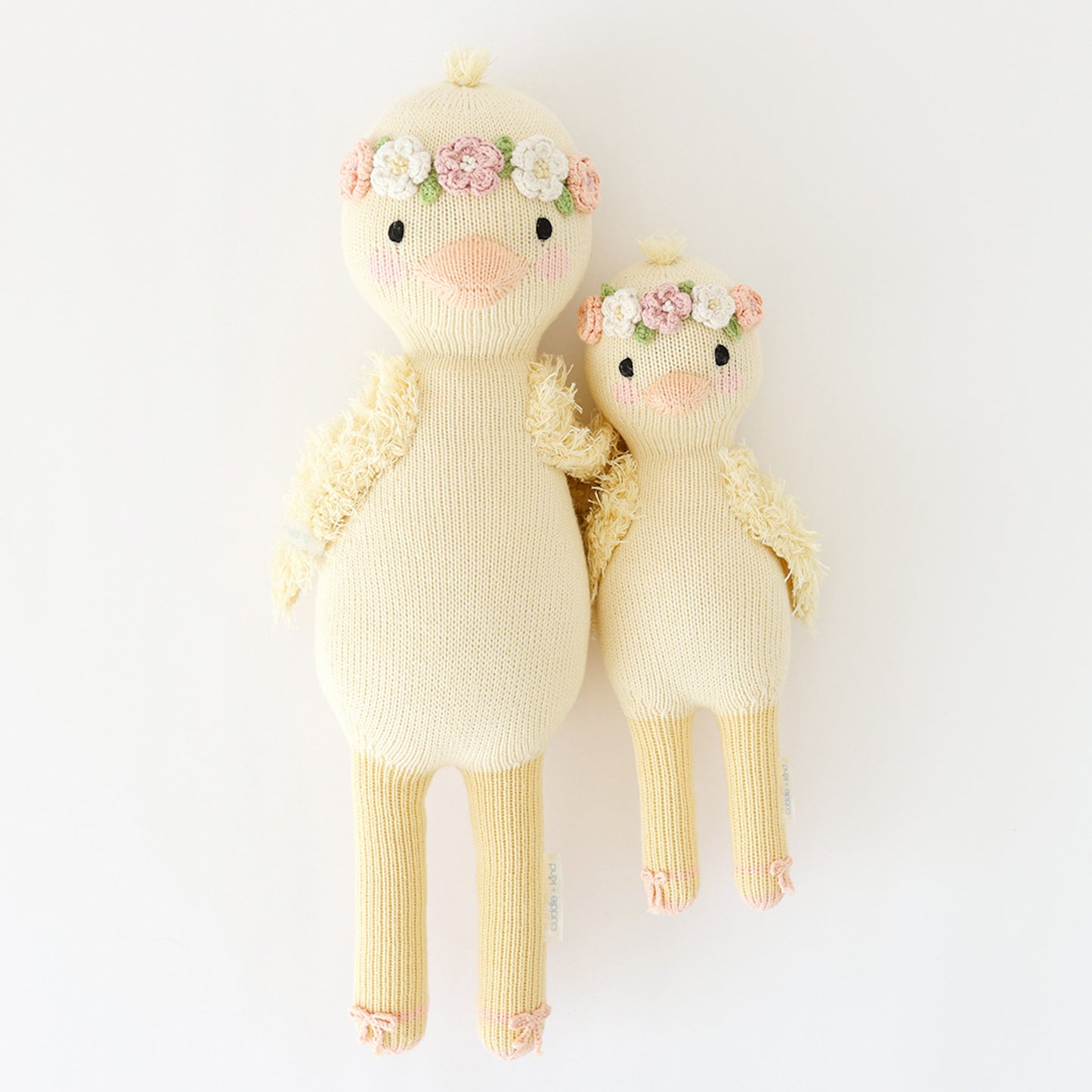 Regular and little Flora the duckling stuffed dolls lying side-by-side.