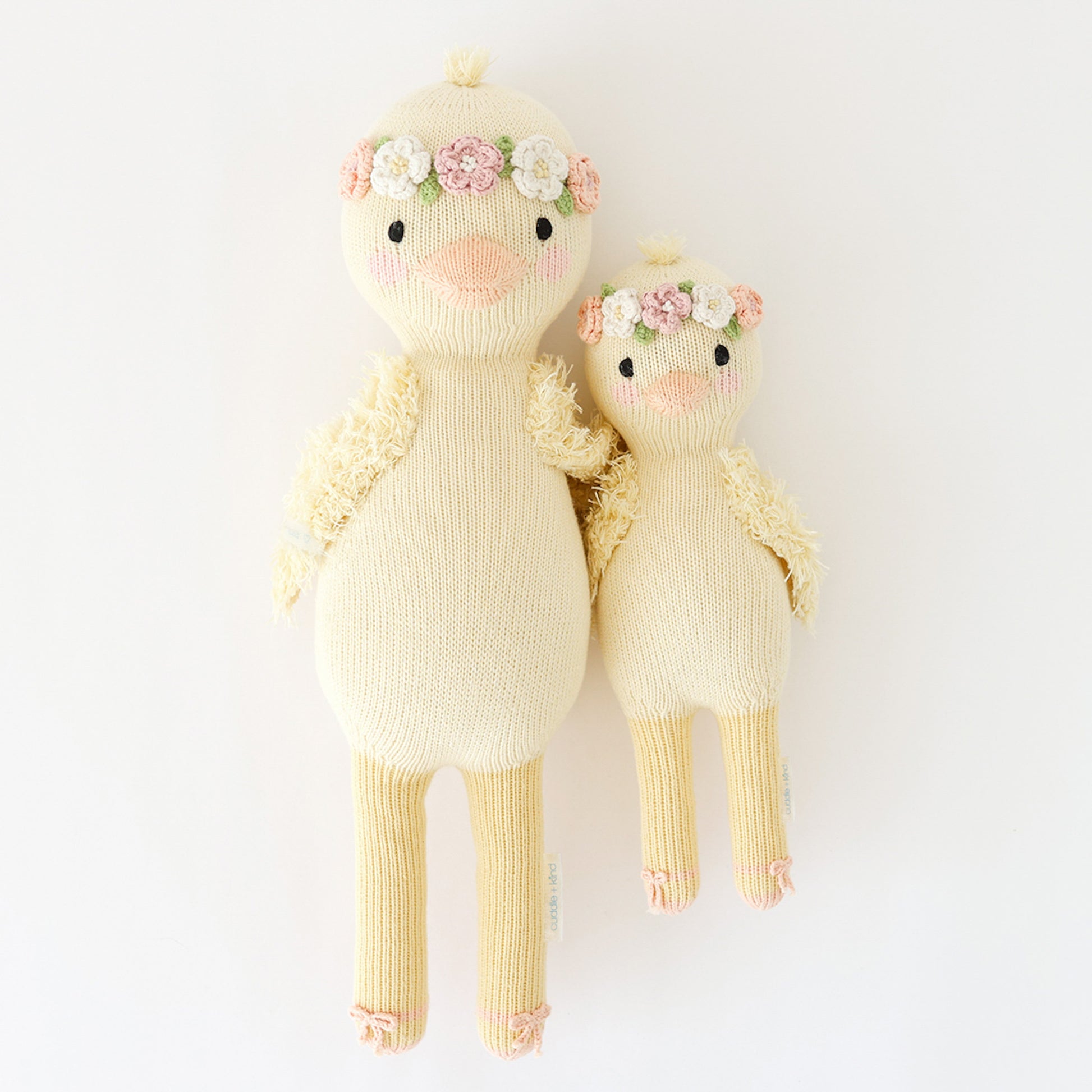 Regular and little Flora the duckling stuffed dolls lying side-by-side.