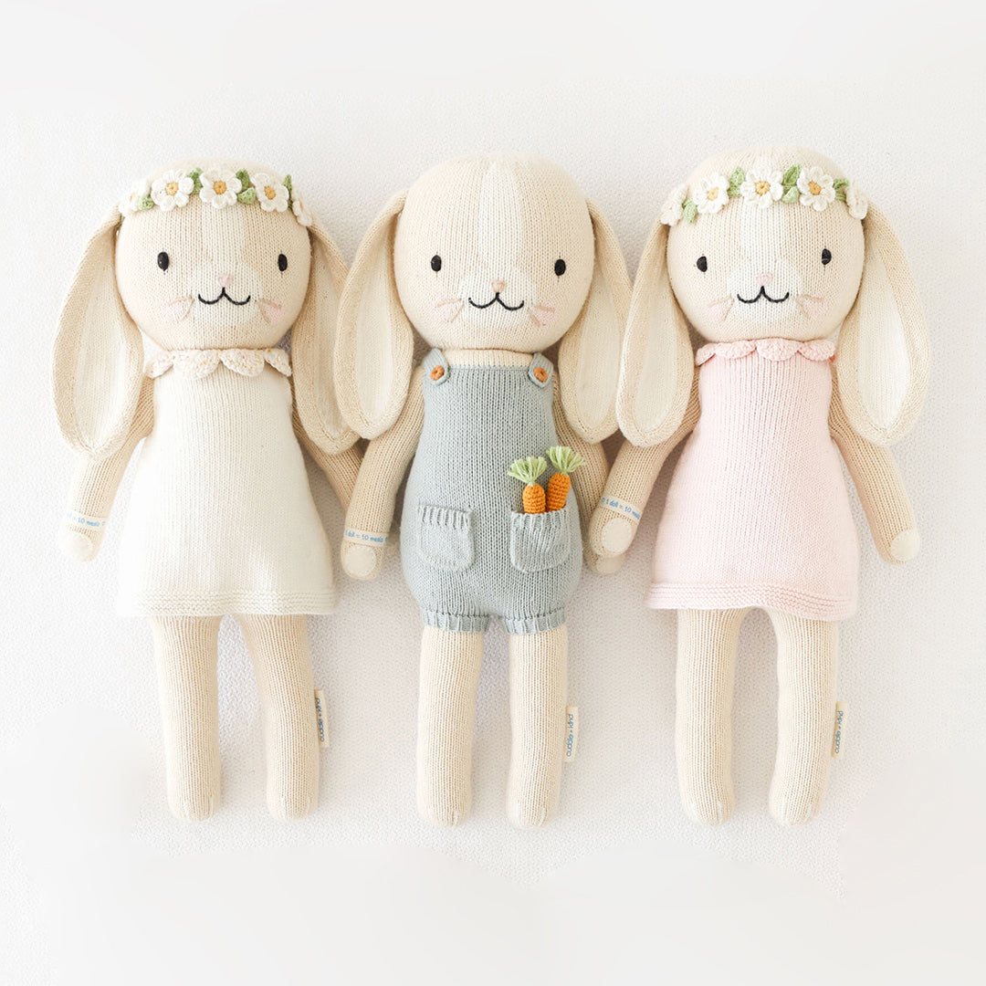 Three hand-knit stuffed bunny dolls: Hannah the bunny in blush and ivory, and Henry the bunny.