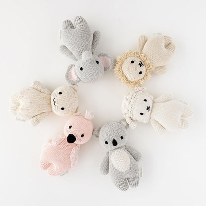 Six baby animal stuffed dolls lying head-to-head in a circle.