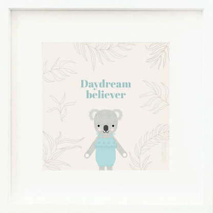 A framed print with a drawing of Claire the koala and text that says “Daydream believer.”
