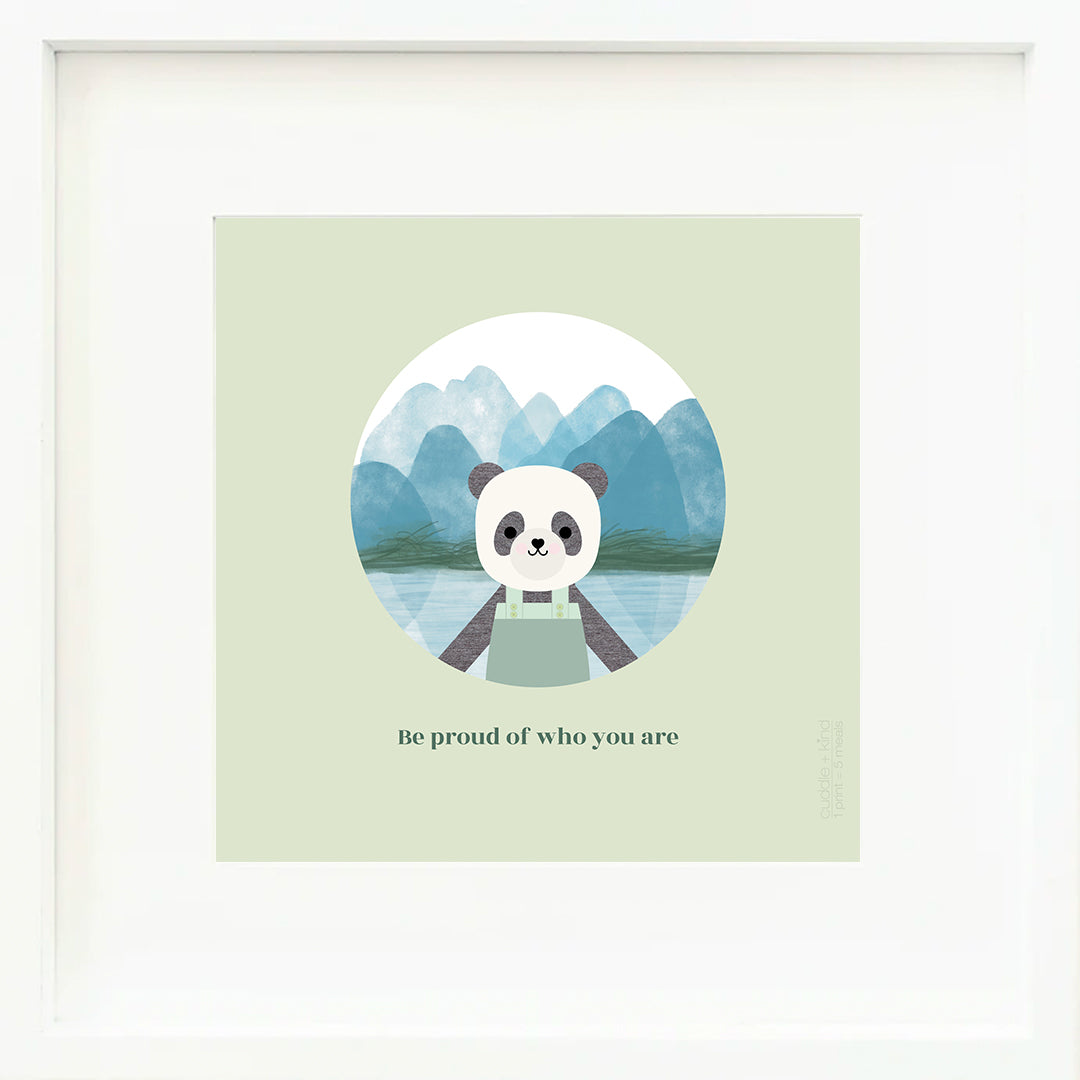 A framed print with a drawing of Paxton the panda, with text that says "Be proud of who you are."