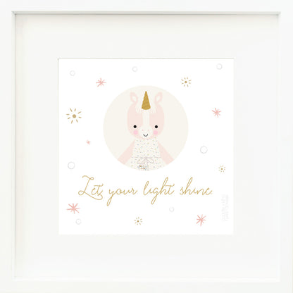 A framed print with a drawing of Ella the unicorn and text that says “Let your light shine.”