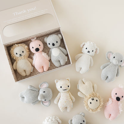 Three baby animals in a baby animal collector’s kit box, next to eight other baby animal dolls. The box has text on it that says “Thank you! You’ve just helped make the world a little better for little ones. This collection provides 15 meals to children in need.”