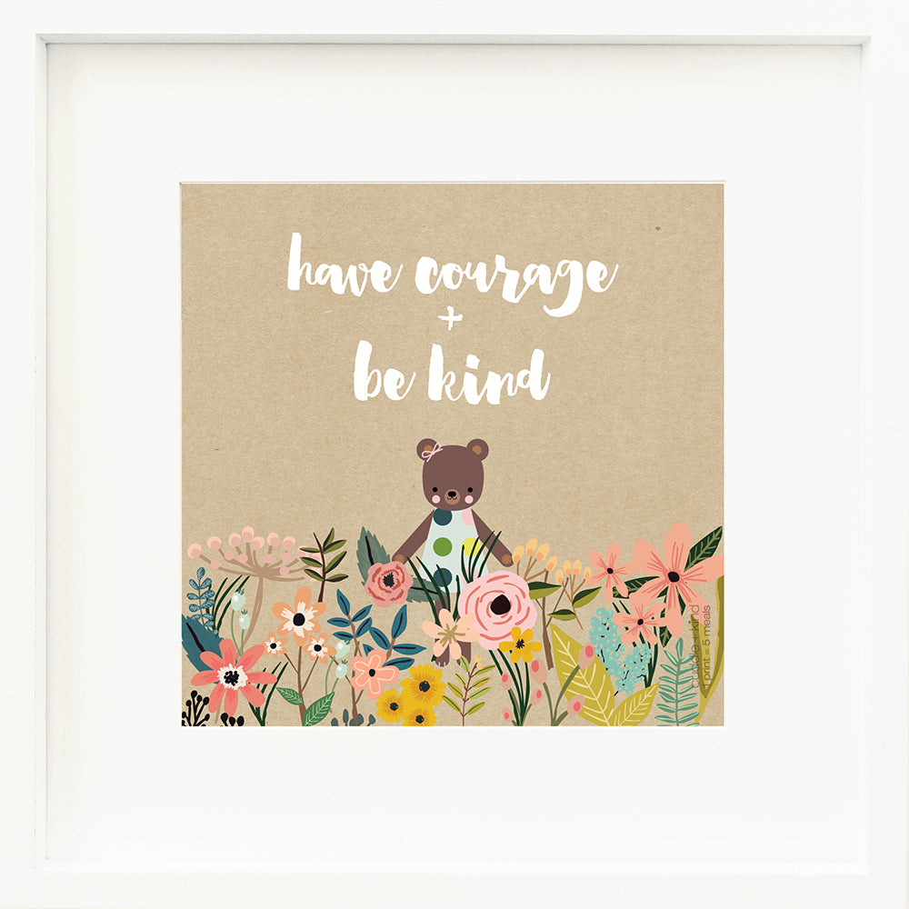 A framed print with a drawing of Ivy the bear and text that says “Have courage + be kind.”