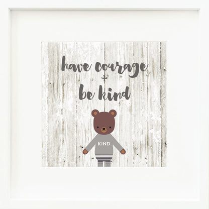 A framed print with a drawing of Oliver the bear and text that says “Have courage + be kind.”