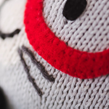 A close-up showing hand-knit details on Benedict the bunny’s face, including his red glasses and hand-knit whiskers.