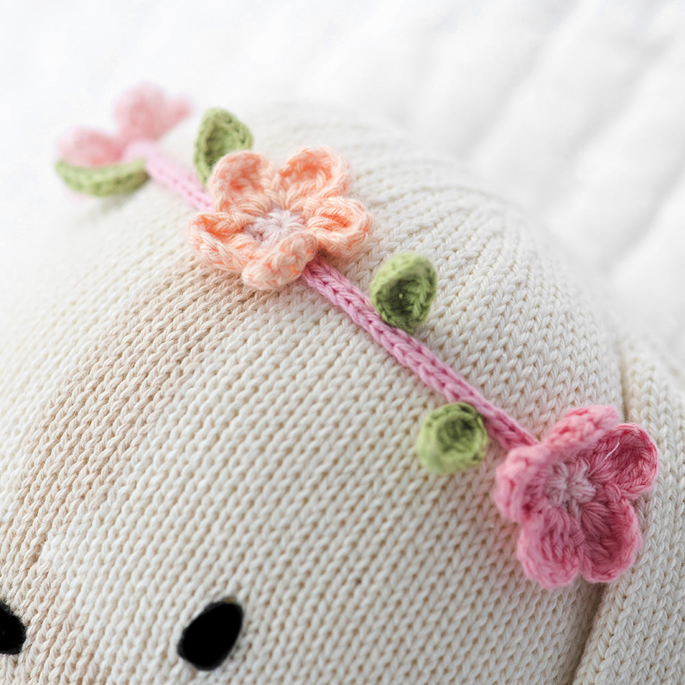 A close-up showing the hand-knit details on Charlotte the dog’s flower headband.