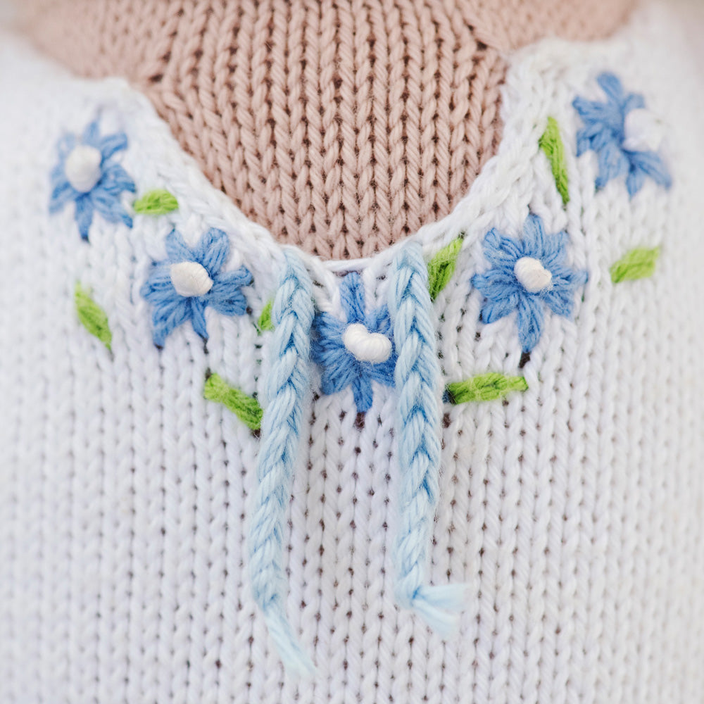 A close-up showing the hand-knit embroidered flowers on Chelsea the cat’s dress.