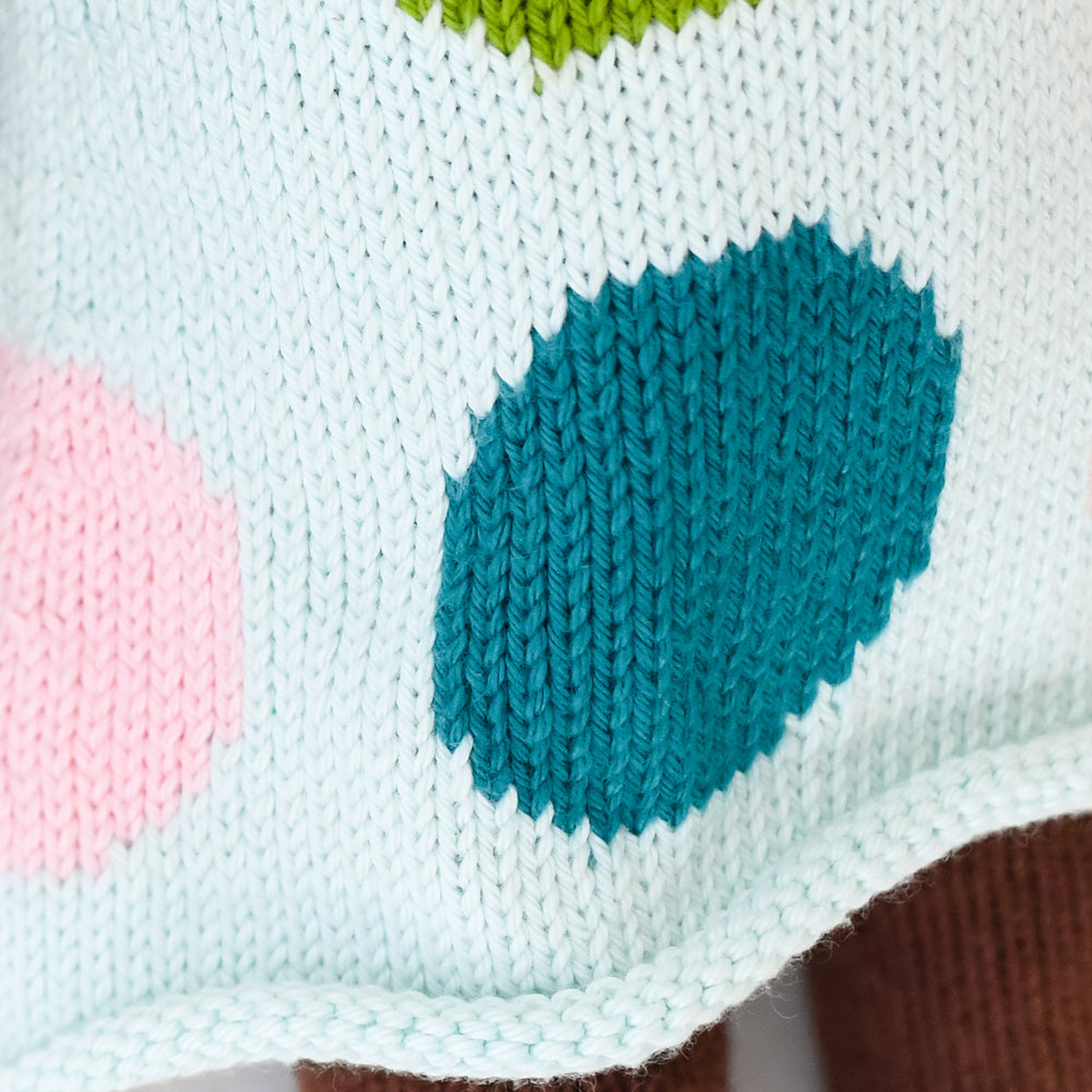 A close-up showing the hand-knit details on Ivy’s polka-dot dress.