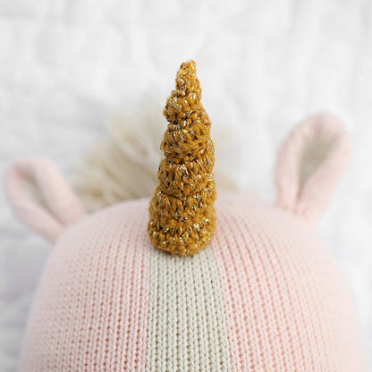 A close-up showing Ella the unicorn’s horn, with silver yarn woven among brown yarn.