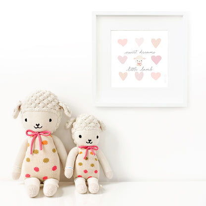 Two Lucy the lamb stuffed dolls sitting beside a framed print with a picture of Lucy that says “Sweet dreams, little lamb.”