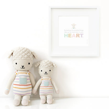 Two Avery the lamb stuffed dolls sitting beside a framed print with a picture of Avery that says “Sometimes the smallest things take up the most room in your heart.”
