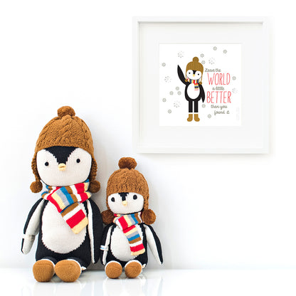 Two Everest the penguin stuffed dolls sitting beside a framed print with a picture of Everest that says “Leave the world a little better than you found it.”
