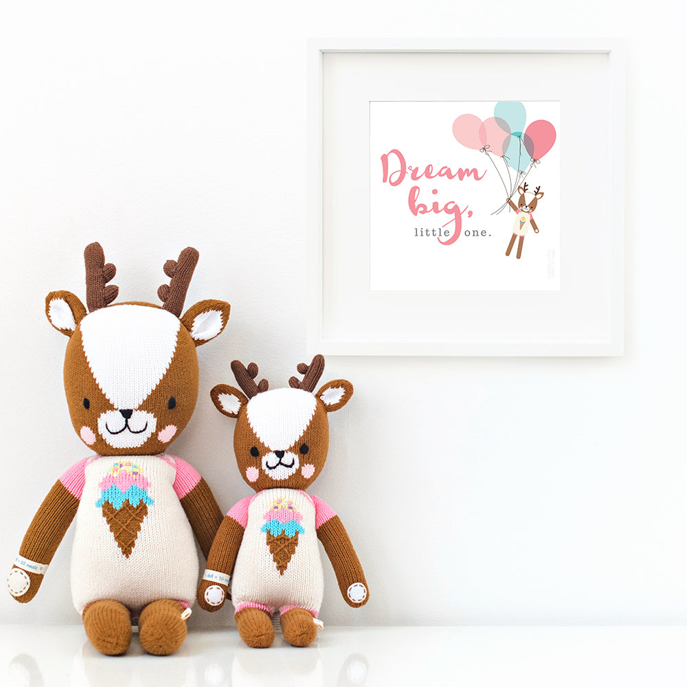 Two Willow the deer stuffed dolls sitting beside a framed print with a picture of Willow that says “Dream big, little one.”