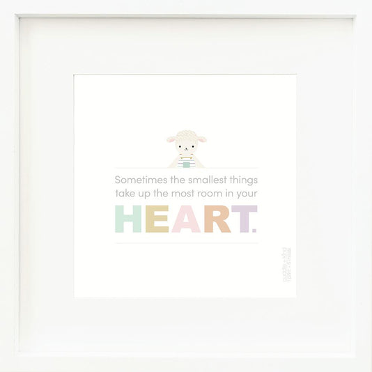 An inspirational print with a graphic of Avery the lamb on a white background with the words “Sometimes the smallest things take up the most room in your heart” in gray, with the word “heart” in rainbow block letters.