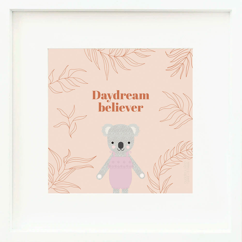 A framed print with a drawing of Claire the koala and text that says “Daydream believer.”