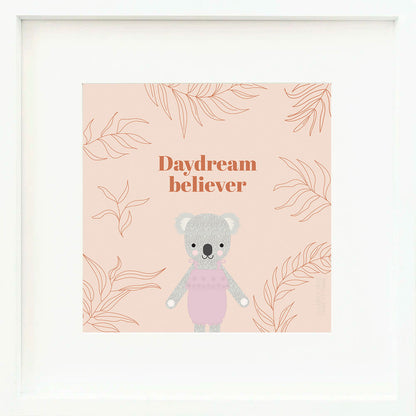 A framed print with a drawing of Claire the koala and text that says “Daydream believer.”