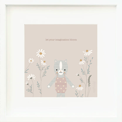 A framed print with a drawing of Daisy the kitten and text that says “Let your imagination bloom.”