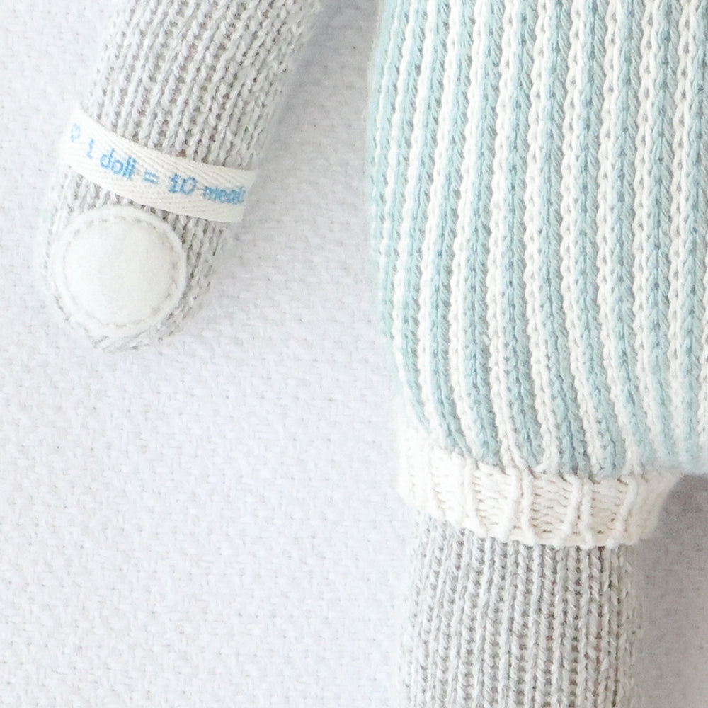 A close-up showing hand-knit details on Dylan the kitten, including the hand-knit cuff on his romper.