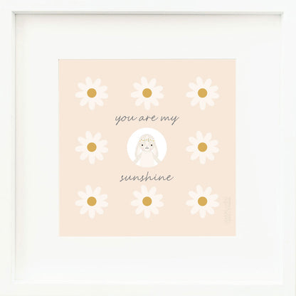 A framed print with a drawing of Hannah the bunny and text that says “You are my sunshine.”