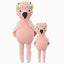 Penelope the flamingo in the regular and little sizes, shown from the front. Penelope has a flower crown, fluffy wings and ballet slippers.