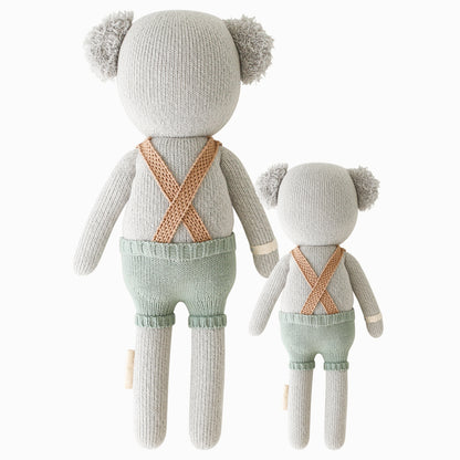 Cuddle and kind doll Quinn the koala in the regular and little sizes, shown from the back. Quinn’s suspenders are criss-crossed in the back.