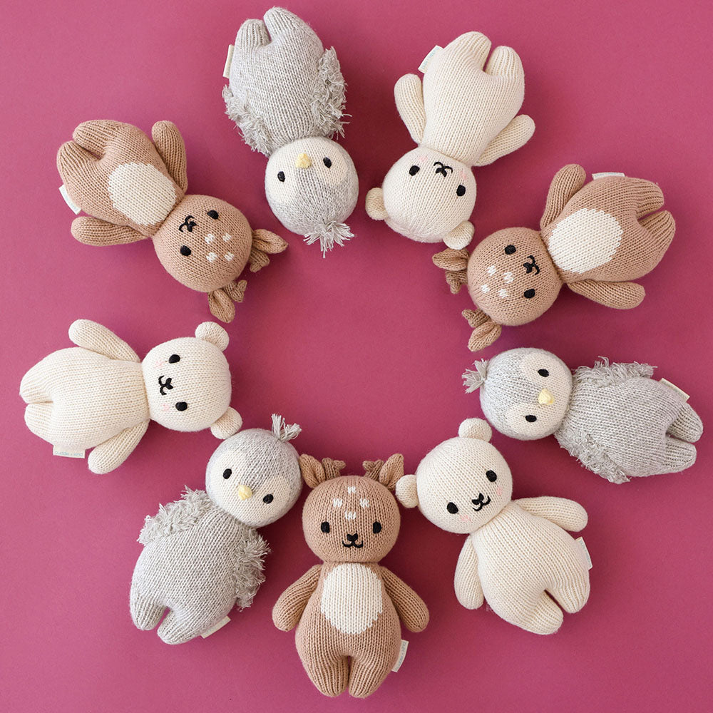 Nine baby animal stuffed dolls lying head-to-head in a circle.
